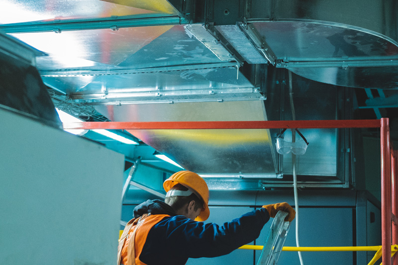 hvac technician working on duct work