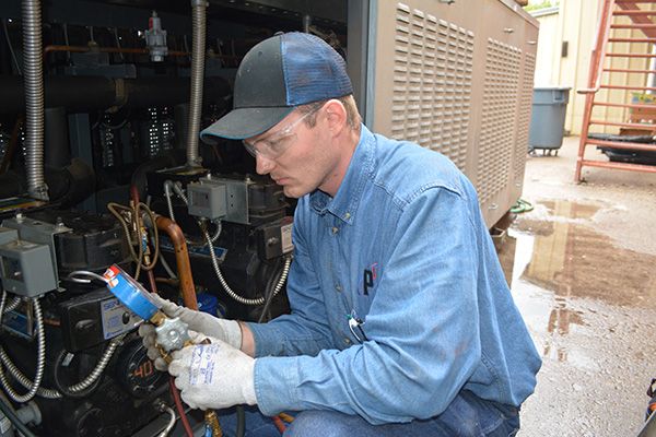 technician inspecting hvac and performing maintenance